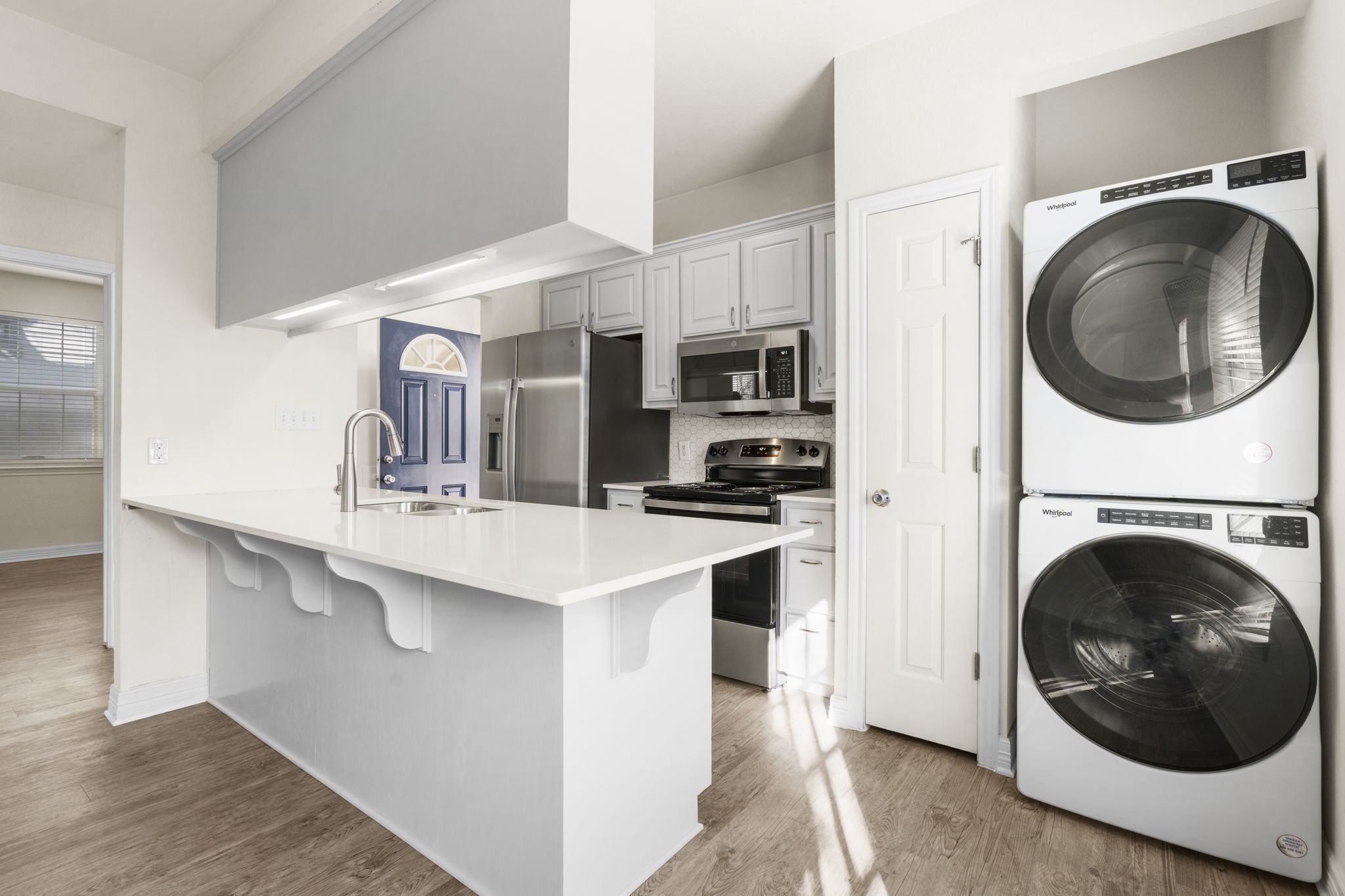 Renovated kitchen with stainless steel appliances and Whirlpool in-unit washer — Whitestone West Campus, West Campus Austin